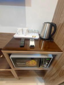 a table with a coffee maker and a coffee pot on it at White Hotel in Quetta