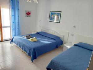 een slaapkamer met 2 bedden en blauwe dekbedden bij Alghero Tour in Alghero