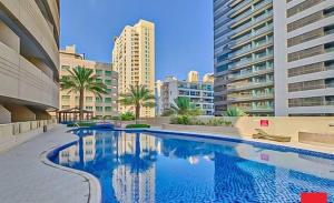 a large swimming pool in a city with tall buildings at Stunning 1Bedroom Apartment - With Amazing Dubai Marina View in Dubai