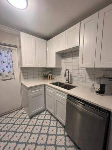 cocina con armarios blancos, fregadero y lavavajillas en Spacious Property at Winter Park - 118 en Orlando