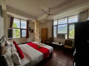 Hotel Eagle Nest Central Heated في دالهوزي: غرفة نوم بها سرير مع أغطية ونوافذ حمراء