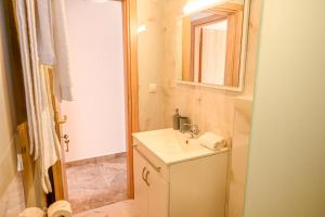 a small bathroom with a sink and a mirror at Sindy's House in Kos Town
