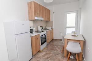 a kitchen with a white refrigerator and a table at Sindy's House in Kos Town +6 photos