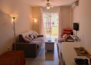 uma sala de estar com um sofá e uma mesa em Relajante apartamento junto al mar en Mijas em Mijas