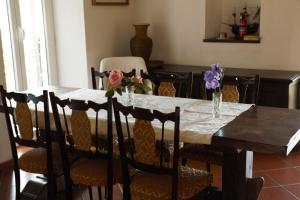 una mesa de comedor con sillas y flores. en Sunrise en Rapallo