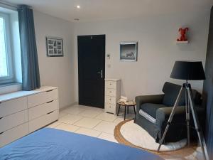 um quarto com um sofá azul e uma porta preta em La Grange des Roisnes em Longué