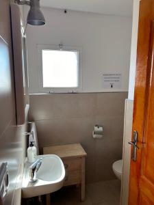 Un baño con lavabo, inodoro y ventana. en La Casa de los Almendros AT-BA-00294, en Guadiana del Caudillo