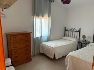 1 dormitorio con 2 camas, vestidor y ventana en La Casa de los Almendros AT-BA-00294, en Guadiana del Caudillo