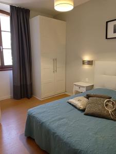 1 dormitorio con 1 cama grande y armario en LA MARMOTTE appartement T2 classé 3 étoiles, en Aulus-les-Bains