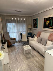 ein Wohnzimmer mit einem weißen Sofa und einem Tisch in der Unterkunft Apartamento Bajondillo Playa y piscina in Torremolinos