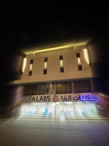 um edifício com uma placa à frente à noite em Jardin an em Abha