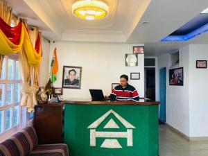 a man sitting at a desk with a laptop at Hotel Eagle Nest Central Heated in Dalhousie