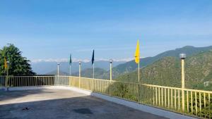 a balcony with flags and a view of a mountain at Hotel Eagle Nest Central Heated in Dalhousie