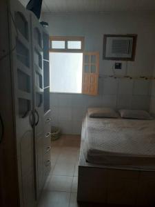 ein kleines Schlafzimmer mit einem Bett und einem Fenster in der Unterkunft Itaparica-BA, o melhor descanso in Vera Cruz de Itaparica