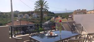 a blue table and chairs on a balcony with a view at Emmanuel apartment in Agia Marina Nea Kydonias