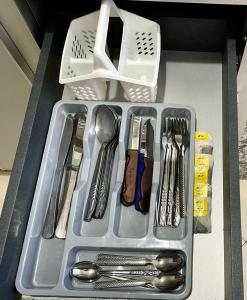 a tray with silver utensils in a drawer at S&H Home Martil Apartment in Martil