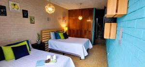 危地馬拉的住宿－Hostal de Lucca，一间卧室设有两张床和蓝色的墙壁