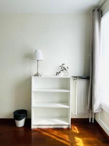 uma prateleira de livros brancos num quarto com um candeeiro em Nouvel Appartement T4 Parking privé - 20 min de Paris em Créteil