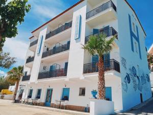 a white building with a palm tree in front of it at Hostal Santa Gemma in Sant Vicenç de Montalt