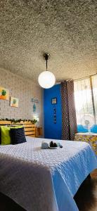 - une chambre avec un grand lit et un mur bleu dans l'établissement Hostal de Lucca, à Guatemala