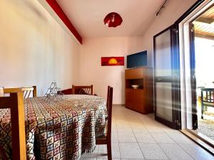 a dining room with a table and a sliding glass door at Casa del Sole in Campofelice di Roccella