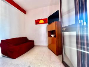 a red couch in a room with a refrigerator at Casa del Sole in Campofelice di Roccella