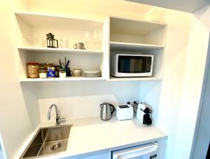 a kitchen with a sink and a microwave at 2 Mile Bay Guesthouse in Taupo