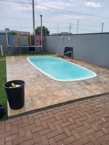 una pequeña piscina en un patio con un cubo en Wm Milão, en Sinop