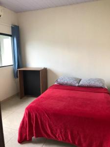 sypialnia z łóżkiem z czerwonym kocem w obiekcie Wm Milão w mieście Sinop