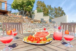 a plate of fruit on a wooden table with drinks at Villa Infinity sea views I Pool I BBQ I Jacuzzi in Almería