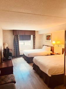 a hotel room with two beds and a television at Lexington Inn & Suites-Windsor in Windsor