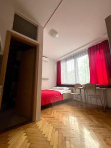 a bedroom with a bed and a table and chairs at Studio apartment Sisters3 in Ljubljana