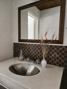 Dúplex La Falda في لا فالدا: بالوعة في الحمام مع مرآة
