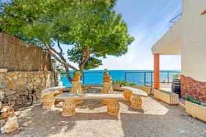 a patio with a bench and a tree and the ocean at Villa Infinity I Sea Views I Saltwater Pool I Jacuzzi I BBQ in Almería
