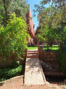 a brick walkway in front of a building with trees at Maison Touria in Ouzoud