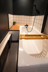 uma casa de banho com uma banheira branca e uma luz no topo em Appartement spacieux et élégant avec jardin em Montivilliers