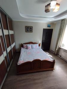 a bedroom with a large wooden bed in a room at Balti house in Bălţi