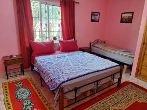 um quarto com uma cama e uma janela em Maison Touria em Ouzoud