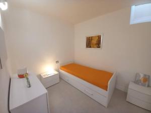 a small white bedroom with a bed with orange sheets at Casa Lina, Vallombrosa, wifi, private area in Tosi