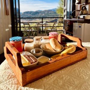 a wooden tray with bread and condiments on a table at ECOREFUGIO in Colbún