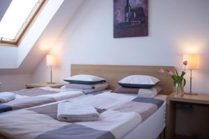 3 Betten in einem Zimmer mit Dachgeschoss in der Unterkunft Gárdonyi Apartman in Eger