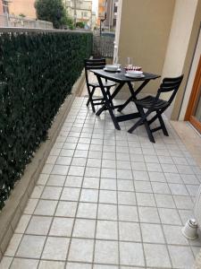 un patio con tavolo e sedie su un pavimento piastrellato di Casa Nives a Sottomarina