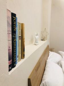 a book shelf with books on it next to a bed at Suites Elifani in Trani