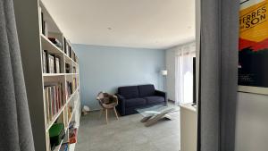 sala de estar con sofá azul y estanterías en Villa des églantines maison jacuzzi bord de mer en Saint-Jean-de-Monts