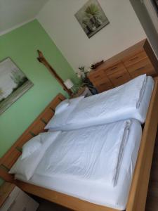 een slaapkamer met een bed met witte lakens bij Wohnung mit Charme in Pinsdorf in Pinsdorf