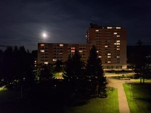 un bâtiment la nuit avec la lune dans le ciel dans l'établissement Luxus-Wohnung am Nationalpark Harz für Aktivurlaub, à Altenau