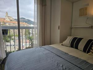 - une chambre avec un lit et une grande fenêtre dans l'établissement Agusta sweethome, à Nice