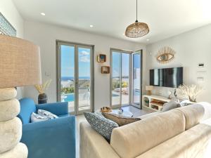 a living room with a couch and a tv at Villa Le22, 180 panoramic sea views, Paros in Kampos Paros