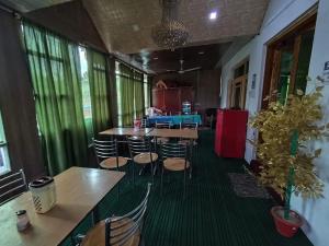 una sala con tavoli e sedie in un ristorante di Hotel New Heaven Canal a Srinagar