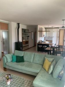 a living room with a green couch and a kitchen at Appartamento Gli Ulivi in Mercato Saraceno